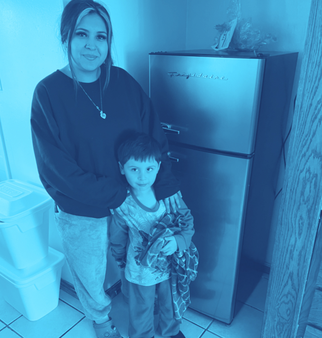 Woman standing with her son in front of a refrigerator.