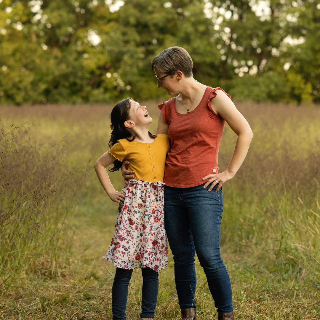 Mom and daughter smiling and connecting in a peaceful outdoor setting